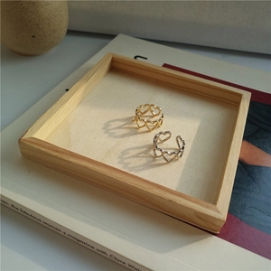 Close-up of gold and silver hollow heart-shaped rings in an aesthetic tray setting