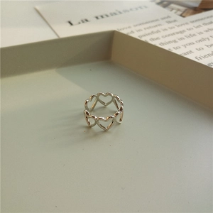 Macro detail of silver heart-shaped hollow ring on minimalist aesthetic display tray