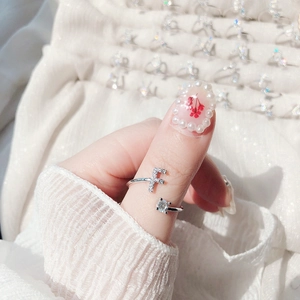 Detail of adjustable silver ring with sparkling letter F and a round solitaire diamond