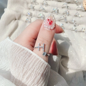 Macro detail of silver H letter ring with pave crystals and square zircon on hand