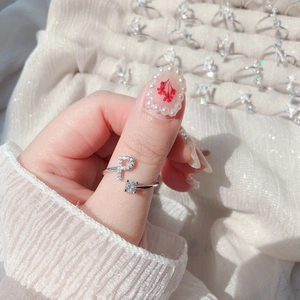 Macro shot of silver letter P ring with pavé crystals and square cubic zirconia on hand