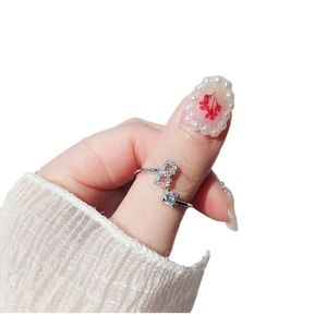 Adjustable silver letter B ring with zircon accents shown on finger with elegant nail art