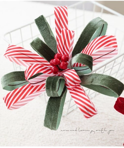 Detail of red and green velvet ribbon bow with red berries for Christmas decor