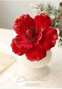 Detail of red velvet Christmas magnolia flower with glitter petals and soft warm lighting
