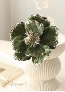 Close-up of luxury dark green velvet Magnolia Christmas flower with gold glitter edges