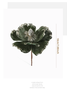 Detailed view of dark green velvet magnolia flower with silver glitter edges for decor