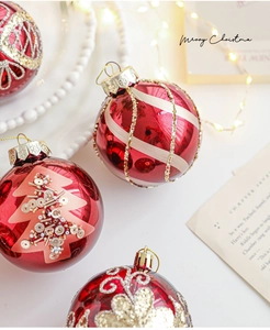 Dettaglio di palline di Natale rosse con motivi glitterati su sfondo festivo