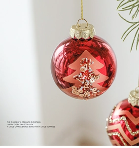 Dettaglio macro di palla di Natale rossa con motivo ad albero artigianale e glitter