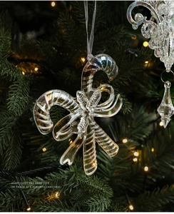 Iridescent acrylic candy cane ornament with a bow on a glowing Christmas tree