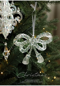 Iridescent bow Christmas ornament with fringe detail hanging on a lit tree
