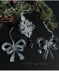 Detail of clear iridescent acrylic Christmas ornaments with snowflake and bow patterns