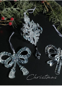 Detail of clear acrylic iridescent Christmas tree ornaments with bow and candy cane shapes