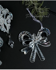 Detail of iridescent acrylic candy cane and snowflake Christmas ornaments on black backdrop