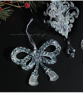 Macro shot of iridescent acrylic Christmas ornaments with ribbons and pine branch detail