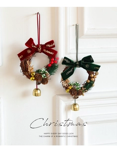 Détail d'une mini couronne de Noël avec nœud en velours et cloches dorées au mur
