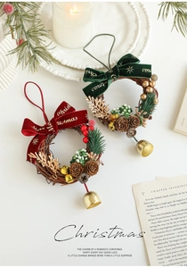 Détail de couronne de Noël avec pommes de pin, cloches dorées et nœud en velours