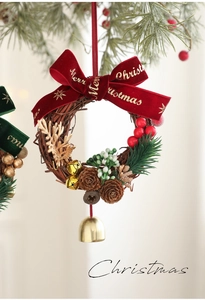 Détail d'une couronne de Noël avec pommes de pin, nœud rouge et petite cloche dorée