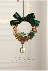 Détail d'une couronne de Noël avec nœud en velours, pommes de pin et cloche dorée