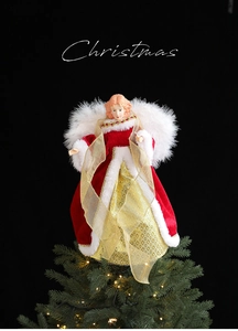 Detail of red velvet Christmas tree topper angel with soft white feather wings