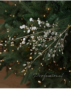 Close-up of elegant Christmas tree branch with white petals and crystal water drops