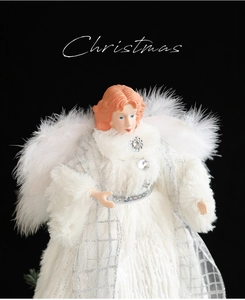Close-up of elegant Christmas angel tree topper with white plush dress and feather wings