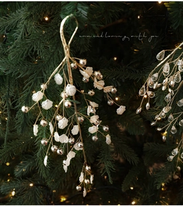 Close-up of elegant Christmas tree branch with white shells and gold beads decoration