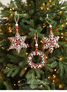 Detail of wooden Christmas gingerbread ornaments with snowflake patterns on a tree