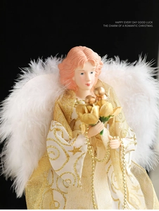 Close-up of elegant Christmas angel tree topper with gold robes and white feather wings