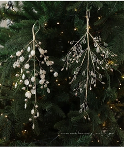 Detail of Christmas tree sprigs with golden branches, crystal droplets, and shell pearls
