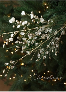 Golden Christmas tree branch with crystal water drops and white flower petals