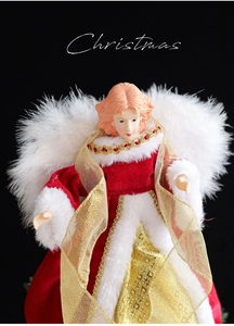Detail of red and gold Christmas tree topper angel with white feather wings and velvet dress