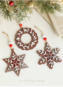 Three-piece wooden Christmas ornaments with snowflake and star designs on festive background