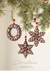 Detail of wooden gingerbread ornaments with white icing on Christmas tree branches