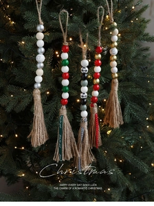Nahaufnahme von Weihnachts-Holzperlenquasten mit Rentier-Prints am Tannenbaum