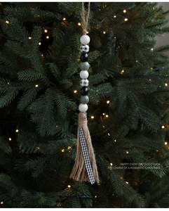 Rustikale Weihnachts-Holzperlen mit Karomuster und Quaste hängen am Weihnachtsbaum
