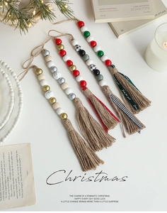 Detailsicht der Weihnachts-Holzperlengirlande mit Quasten und Rentier-Drucken
