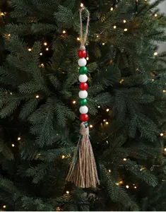 Nahaufnahme von rot-weiß-grünen Holzperlen mit Quaste an einem Weihnachtsbaum