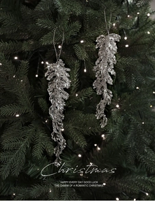 Detail of elegant champagne pink acrylic leaf pendants on a lit Christmas tree