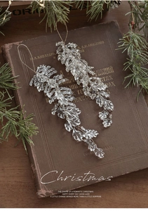 Detail of crystal acrylic leaf ornaments with icy textures on vintage book background