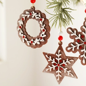 Three-piece wooden Christmas pendants with snowflake and star designs on pine branches