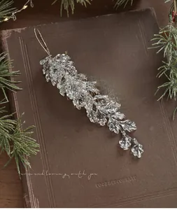 Close-up of champagne acrylic leaf pendant with gold string on a vintage book