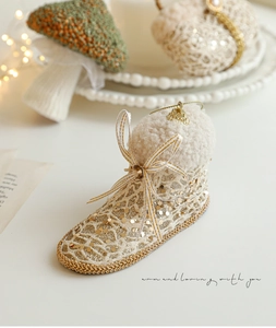 Detail van champagne kant kerstlaars ornament met gouden lovertjes en witte imitatiebont