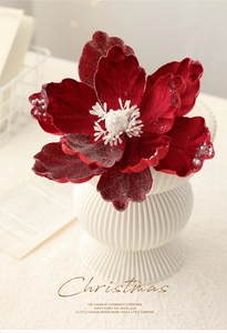 Detail of dark red velvet Christmas flower with white pearl edges in a ceramic vase