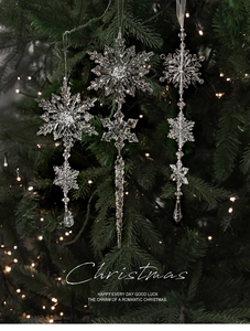Nahaufnahme von klaren Acryl-Schneeflocken und Eiszapfen an einem Weihnachtsbaumzweig