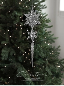 Detail von klaren Acryl-Schneeflocken und Eiszapfen am beleuchteten Weihnachtsbaum