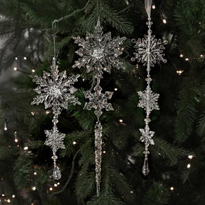Acryl-Schneeflocken-Anhänger mit Silberglitzer an einem beleuchteten Tannenbaum