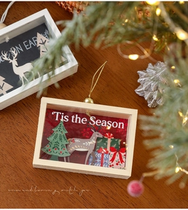 Close-up of wooden Christmas frame with 3D reindeer and tree design for table decor