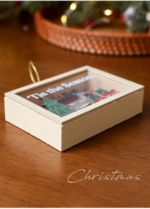 Detail of wooden Christmas shadow box ornament with 3D tree and golden hanging cord