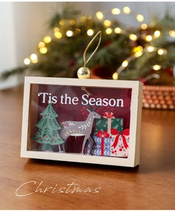 Close-up of 3D wooden Christmas ornament with reindeer, tree and Tis the Season text