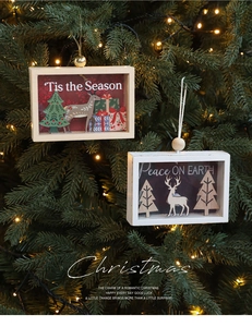 Close-up of wooden Christmas ornaments with 3D reindeer and trees on a warm lit tree